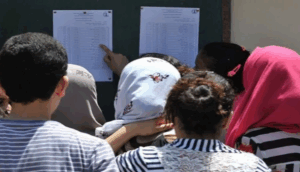 طلاب يتفقدون نتائج الامتحانات على لوحة الإعلانات