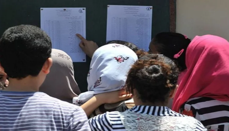 طلاب يتفقدون نتائج الامتحانات على لوحة الإعلانات